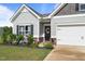 Inviting front entrance with a decorative wreath, manicured landscaping, and a freshly sealed driveway at 41 Liam Dr, Broadway, NC 27505