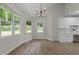 Bright dining area with a modern light fixture, a built-in office space, and backyard views at 6008 Chittim Ct, Raleigh, NC 27616