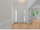 Bright foyer with hardwood floors, paneled walls, and a chandelier, leading to the rest of the house at 6008 Chittim Ct, Raleigh, NC 27616
