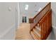 A sunlit view of the staircase and living room featuring a fireplace and wood floors, enhancing the home's interior at 6008 Chittim Ct, Raleigh, NC 27616