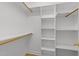 A bright walk-in closet provides ample storage with adjustable shelving and wooden rods at 6008 Chittim Ct, Raleigh, NC 27616