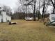 Wide backyard featuring a mix of grass, trees, parked vehicles, and detached garage with potential for outdoor activities at 6908 Park Pl, Raleigh, NC 27616