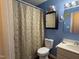 Bathroom with blue walls, neutral shower curtain, and single sink vanity at 6908 Park Pl, Raleigh, NC 27616