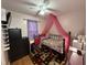 Bedroom with a bed canopy, desk, and wood-look flooring at 6908 Park Pl, Raleigh, NC 27616