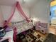 Bedroom with bed canopy, laminate flooring and pink toy kitchen at 6908 Park Pl, Raleigh, NC 27616