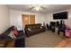 Living room with a sectional sofa, TV, and neutral carpet at 6908 Park Pl, Raleigh, NC 27616