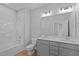 Bathroom featuring dual sinks, gray cabinets, a bath tub, and white walls at 701 Jamescroft Way, Rolesville, NC 27571