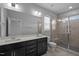 Contemporary bathroom featuring a double vanity, a large mirror, and a glass-enclosed shower at 701 Jamescroft Way, Rolesville, NC 27571