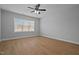 Empty bedroom featuring wood floors, a ceiling fan, and a large window at 701 Jamescroft Way, Rolesville, NC 27571