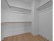 Walk-in closet with wood floors, white walls and trim, and wooden shelves at 701 Jamescroft Way, Rolesville, NC 27571
