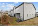 View of the rear of the townhomes with gray siding and small patches of grass at 701 Jamescroft Way, Rolesville, NC 27571