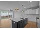 Modern open-concept kitchen with white cabinets, island with sink, and access to backyard patio at 701 Jamescroft Way, Rolesville, NC 27571