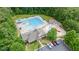 Resort style swimming pool with slides, splashpad, and a clubhouse surrounded by trees and parking at 7336 Capulin Crest Dr, Apex, NC 27539