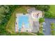 Birds eye view of the community pool with a splash pad, lounge chairs, umbrellas, and a clubhouse at 7336 Capulin Crest Dr, Apex, NC 27539