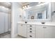 Bright bathroom featuring a double vanity with white cabinets, a large mirror, and a view to the toilet at 7336 Capulin Crest Dr, Apex, NC 27539