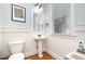 Bright half bathroom with pedestal sink, wainscoting, and stylish decor at 7336 Capulin Crest Dr, Apex, NC 27539