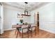 Beautiful dining room with wainscoting, hardwood floors, and designer lighting at 7336 Capulin Crest Dr, Apex, NC 27539