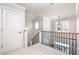 Second-floor foyer featuring wrought iron railings, wood staircase and natural light at 7336 Capulin Crest Dr, Apex, NC 27539