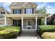 Charming front porch featuring brick detail, white columns, and manicured shrubbery at 7336 Capulin Crest Dr, Apex, NC 27539