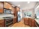 Gourmet kitchen featuring stainless steel appliances, granite countertops, and wood cabinetry at 7336 Capulin Crest Dr, Apex, NC 27539