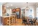 Open kitchen with wood cabinets, granite countertops, stainless steel appliances, and breakfast bar seating at 7336 Capulin Crest Dr, Apex, NC 27539