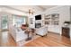 Cozy living room featuring a fireplace, built-in shelves, and hardwood floors at 7336 Capulin Crest Dr, Apex, NC 27539