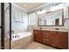 Main bathroom with double vanity, granite countertops, soaking tub, and tile flooring at 7336 Capulin Crest Dr, Apex, NC 27539