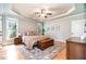 Relaxing bedroom with tray ceiling, ceiling fan, large windows and hardwood floors at 7336 Capulin Crest Dr, Apex, NC 27539
