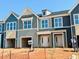 Modern townhome exterior featuring varied siding colors, large windows, and attached garages, offering contemporary living at 99 Ripple Way # 211, Clayton, NC 27520