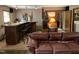 Basement living area featuring a bar, leather couch and neutral colored carpet with warm toned walls at 10 Winchester Ct, Durham, NC 27707