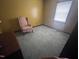 A bedroom featuring a green carpet, a pink armchair and a lamp atop a three-drawer dresser at 10 Winchester Ct, Durham, NC 27707