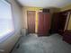 A bedroom featuring a green carpet, a brown cabinet and a set of doors at 10 Winchester Ct, Durham, NC 27707