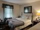A bedroom with a neatly made bed, neutral-toned walls, and a window with light filtering through blinds at 10 Winchester Ct, Durham, NC 27707