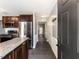 View of kitchen with stainless appliances, dark wood cabinets, and granite countertops from entryway at 102 Sanair Ct, Apex, NC 27502