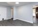 An empty living room with light gray walls, gray floors, and white trim at 102 Sanair Ct, Apex, NC 27502