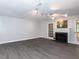 Spacious living room with a fireplace, stylish lighting, and access to the outdoors at 102 Sanair Ct, Apex, NC 27502