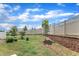 Landscaped backyard with a privacy fence, lush green lawn, and retaining wall at 1021 Shellbank Dr, Durham, NC 27703
