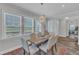 Bright dining room with a rustic table, elegant chandelier, and large windows at 1021 Shellbank Dr, Durham, NC 27703