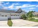 Spacious two car garage with white doors and concrete driveway framed by a well manicured lawn at 1021 Shellbank Dr, Durham, NC 27703