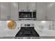 Close-up of kitchen featuring stainless steel microwave and gas range with white subway tile backsplash at 1021 Shellbank Dr, Durham, NC 27703