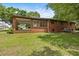 Back exterior of a brick ranch-style home with a covered porch, ideal for outdoor living and relaxation at 1051 Old Us 421, Lillington, NC 27546