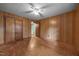 Bedroom with panel walls, ceiling fan, hardwood floors, closet, and view to another room at 1051 Old Us 421, Lillington, NC 27546