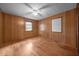 Bedroom with paneled walls, hardwood floors, ceiling fan, and natural light from a window at 1051 Old Us 421, Lillington, NC 27546