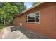 Side view of brick home showcasing large windows and a concrete patio at 1051 Old Us 421, Lillington, NC 27546