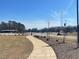 Scenic view of a curved walking path leading to playground, with trees and open skies at 109 Arundel Dr, Archer Lodge, NC 27527