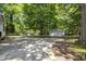 A spacious backyard has a large concrete pad, mature trees, and a storage shed at 112 Rectory St, Oxford, NC 27565