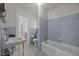 Bathroom featuring blue tiling, a toilet, and a bathtub with a showerhead, showcasing classic bathroom fixtures at 112 Rectory St, Oxford, NC 27565