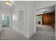 Hallway with neutral carpet, bright white trim, and doorways leading to rooms with wood-paneled walls at 112 Rectory St, Oxford, NC 27565