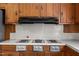 The kitchen features an electric cooktop with a stainless steel range hood above at 112 Rectory St, Oxford, NC 27565