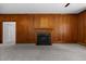 Cozy living room with wood-paneled walls, fireplace, neutral carpet, and natural light at 112 Rectory St, Oxford, NC 27565